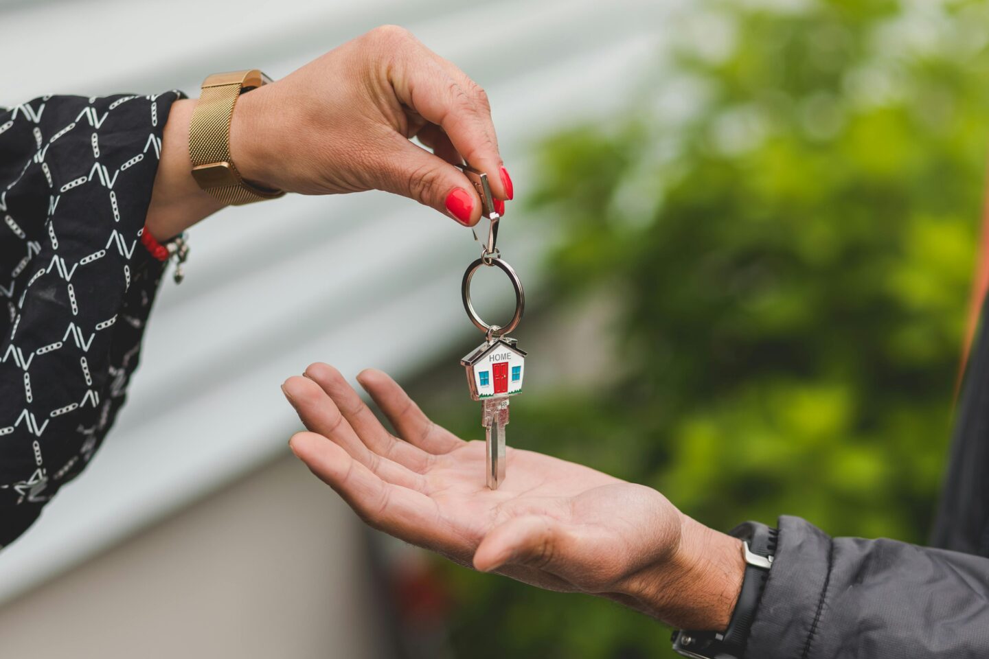 Female landlord handing over house keys – visualising landlord burnout support and responsible property management.